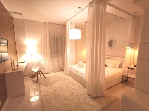 ein weißes Schlafzimmer mit einem Bett und einem Spiegel in der Unterkunft Villa Santo in Babići