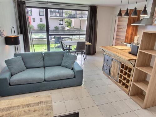 un salon avec un canapé bleu et une table dans l'établissement Appartement lumineux à Colmar avec terrasse, parking et WiFi – 5 min du centre - FR-1-722-1, à Colmar