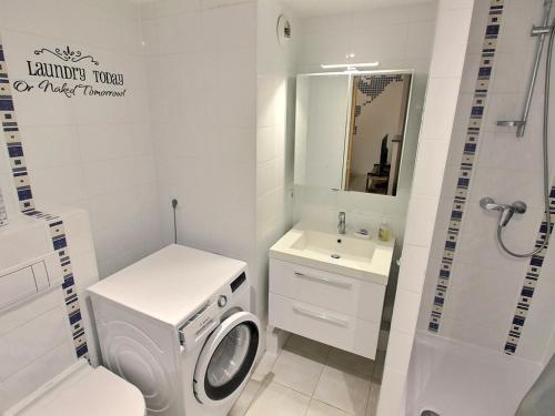 une salle de bain blanche avec une machine à laver et un lavabo dans l'établissement Appartement lumineux à Colmar avec terrasse, parking et WiFi – 5 min du centre - FR-1-722-1, à Colmar