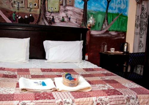 een bed met twee handdoeken en een mand erop bij To Be Hotel in Kumasi