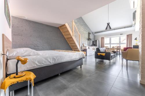 een slaapkamer met een bed en een bakstenen muur bij De Hoog Velden 15 in Overpelt