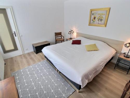 une chambre avec un grand lit blanc et deux chaises dans l'établissement Appartement spacieux à Colmar avec terrasse, garage privatif, proche centre et gare - FR-1-722-2, à Colmar
