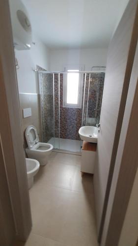 a bathroom with a toilet and a sink and a shower at La Dimora del Salento in Torre Lapillo