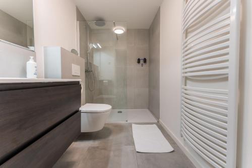 a white bathroom with a toilet and a shower at De Hoog Velden 15 in Overpelt