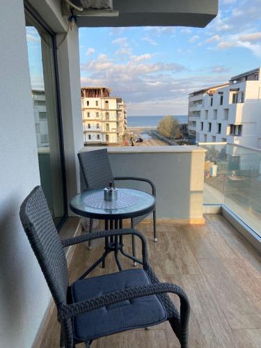 a table and chairs on a balcony with a view of the ocean at Anastasia Residence in Năvodari