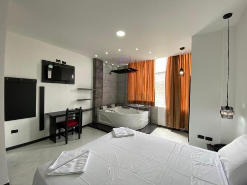 a bedroom with a bed and a bath tub at BRYSS HOTEL in Santo Domingo de los Colorados