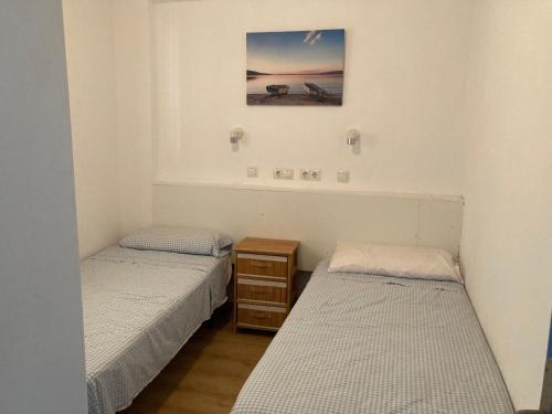 Zimmer mit 2 Betten und einem Bild an der Wand in der Unterkunft Apartamento 1ª linea de mar in Almería