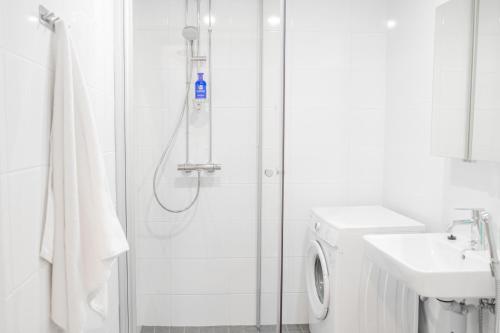 a white bathroom with a shower and a sink at Snowflake suites V in Rovaniemi
