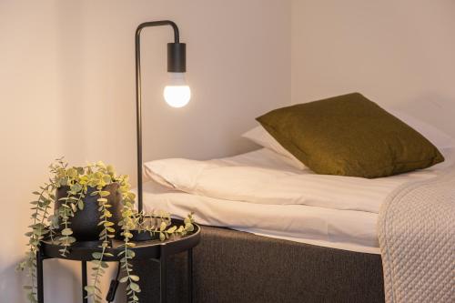 ein Schlafzimmer mit einem Bett und einem Tisch mit einer Topfpflanze in der Unterkunft Snowflake suites V in Rovaniemi