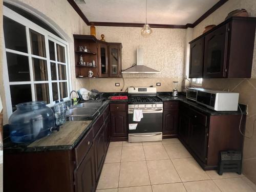 a kitchen with a sink and a stove top oven at Hotel Quinta Maya in Flores