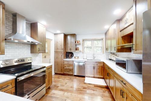 a kitchen with wooden cabinets and stainless steel appliances at Norris Lake Escape in New Tazewell