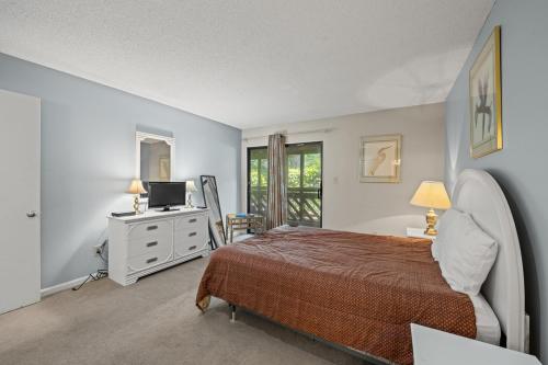 Schlafzimmer mit einem Bett und einem Schreibtisch mit einem TV in der Unterkunft Heron Pointe D2 in Myrtle Beach