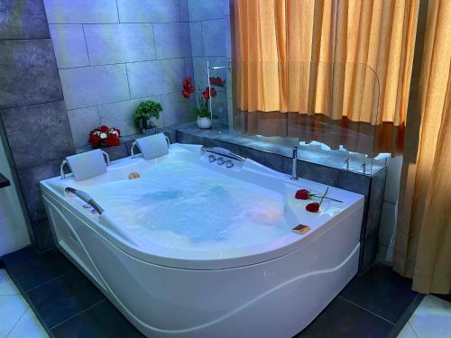 y baño con bañera grande. en BRYSS HOTEL, en Santo Domingo de los Colorados