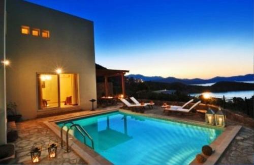 a large swimming pool in front of a house at Istron Collection Villas in Istron