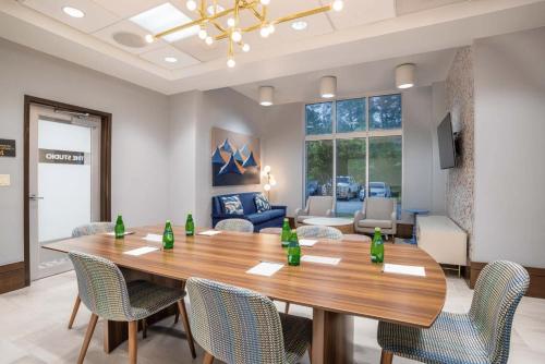 a dining room with a large wooden table and chairs at Crowne Plaza Shenandoah - The Woodlands Area by IHG in The Woodlands