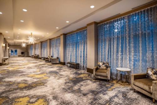 a waiting room with couches and chairs and windows at Crowne Plaza Shenandoah - The Woodlands Area by IHG in The Woodlands