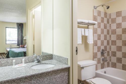 a bathroom with a sink and a toilet and a mirror at Super 8 by Wyndham Norcross/I-85 Atlanta in Norcross