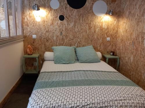 1 dormitorio con 1 cama con 2 almohadas en Location Studio indépendant avec terrasse ,les vignes d'élian, en Saint-Médard-en-Jalles