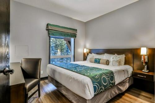 a bedroom with a bed and a chair and a window at Outstanding Mountain Condo *WATERSLIDE* HOTTUB* hosted by Fenwick Vacation Rentals in Canmore