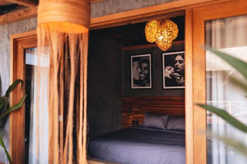 a bedroom with a bed and a chandelier at Naked Hotel Zipolite -Adults Only- in Zipolite