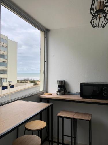 une pièce avec une table et deux tabourets et une fenêtre dans l'établissement Studio vue mer, à Saint-Hilaire-de-Riez