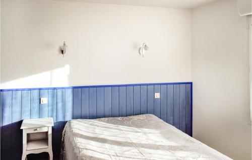 Un dormitorio con una cama azul y blanca y una mesa en Gorgeous Apartment In Saint-pe-sur-nivelle With House A Panoramic View en Saint-Pée-sur-Nivelle