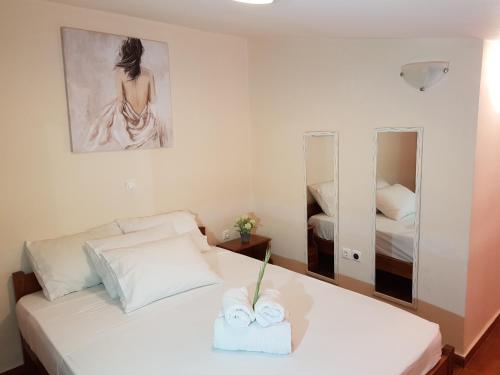 a bedroom with a white bed with two towels on it at Mat Old Town Apartments L in Rethymno