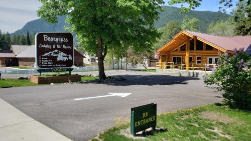a sign in front of a log cabin at Beargrass Lodging & RV Resort in Hungry Horse