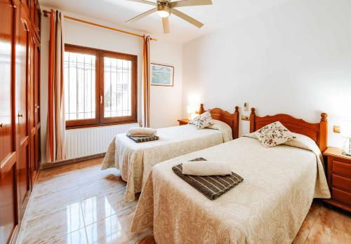 1 dormitorio con 2 camas y ventana en Cal Nano Casa Rural, en Vall-Llobrega