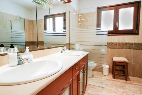 y baño con lavabo, espejo y aseo. en Cal Nano Casa Rural, en Vall-Llobrega