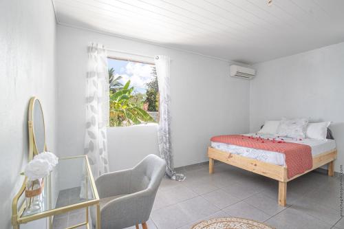 Schlafzimmer mit einem Bett und einem Fenster in der Unterkunft Haut de villa au François in Le François