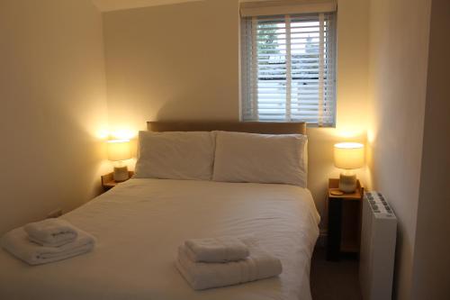 a bedroom with a white bed with two towels on it at Rossett Pike in Bowness-on-Windermere