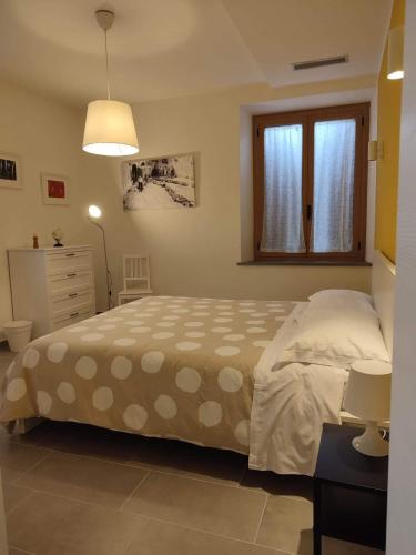 a bedroom with a bed and a dresser and a window at Il glicine - Primula in Paciano