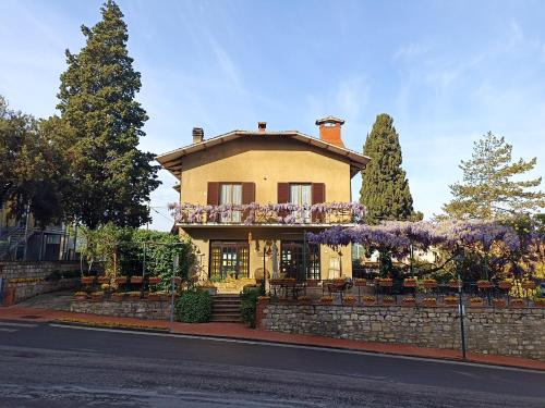 a house with flowers on the side of it at Il glicine - Primula in Paciano