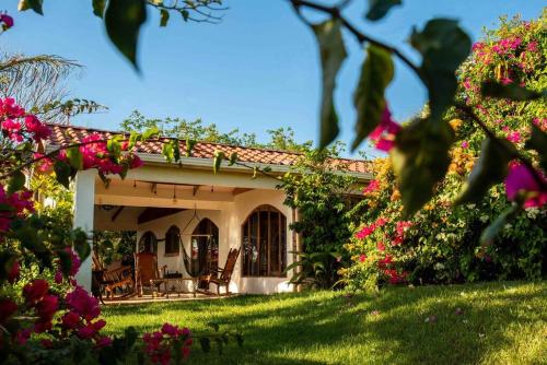 Tilarán的住宿－Gateway to Paradise，院子里有粉红色花的房子