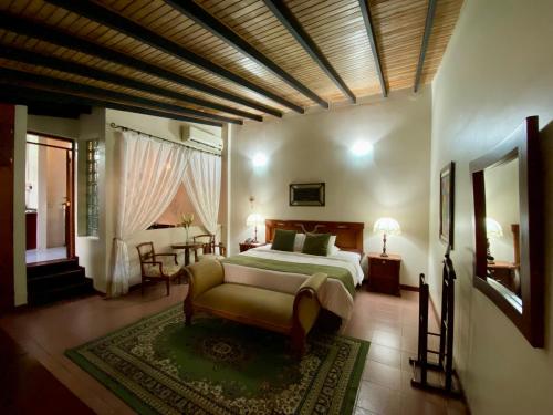 a bedroom with a bed and a couch and a table at Posada El Remanso de Pueblo Nuevo in San Cristóbal