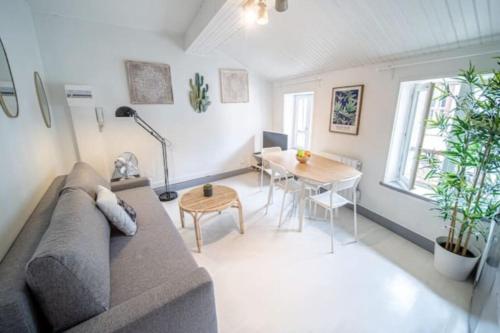 a living room with a couch and a table at Le San Diego - Appartement 4 pers Oullins-Lyon in Oullins