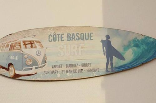 a surfboard with a picture of a surfer on it at Maison - Terrasse - Jardin in Préchacq