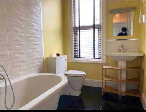 ein Badezimmer mit einer Badewanne, einem WC und einem Waschbecken in der Unterkunft 7 Bed Home*Contractors*CityCentre*FREE Parking in Derby