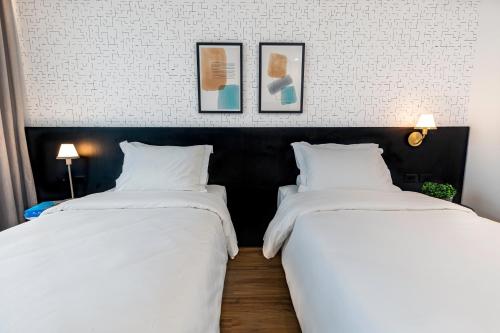 two beds sitting next to each other in a room at Intercity Tatuapé in São Paulo