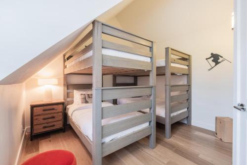 a bedroom with two bunk beds and a red chair at Lake Placid Lodge by Outpost Whistler in Whistler