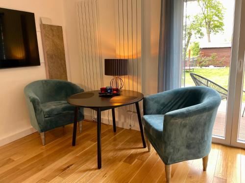 uma sala de estar com uma mesa e duas cadeiras e um candeeiro em Elbsleep em Dömitz