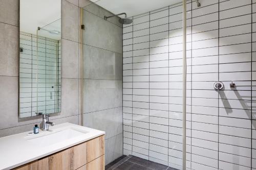 uma casa de banho com um lavatório e um chuveiro em Belina - Matrix Premier na Cidade do Cabo