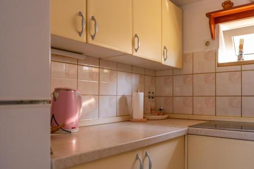 a kitchen with white cabinets and a pink blender at Isola Bella in Korčula