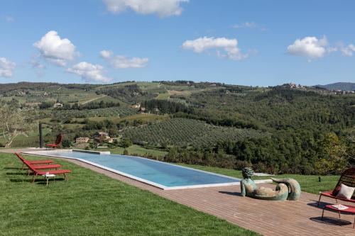 una piscina en la cima de una exuberante colina verde en PODERE 1384, en Castellina in Chianti