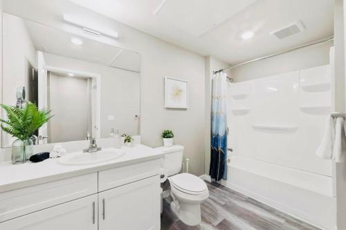 La salle de bains blanche est pourvue d'une douche et de toilettes. dans l'établissement Chic Apt with Jacuzzi, Pool Nr Casino & Shopping, à Sparks