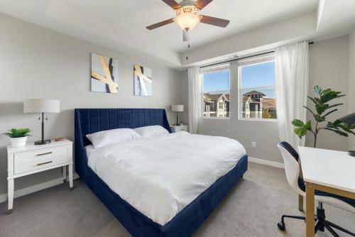 a bedroom with a bed and a desk and a ceiling fan at Designer Apt with Jacuzzi, Pool & Mountain Views in Sparks