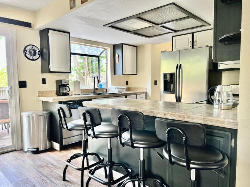 a kitchen with a counter and bar stools at DT Reno - 4BR Home with Patio, BBQ Grill, Games Room in Reno