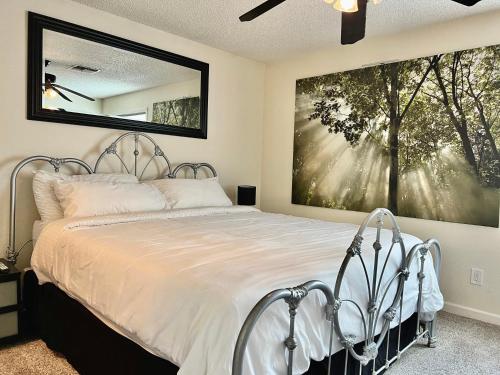 een slaapkamer met een bed met een groot schilderij aan de muur bij DT Reno - 4BR Home with Patio, BBQ Grill, Games Room in Reno