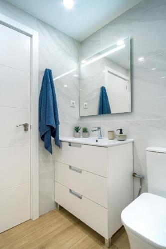 a white bathroom with a sink and a mirror at Apartament Glamour La Mata in Torrevieja